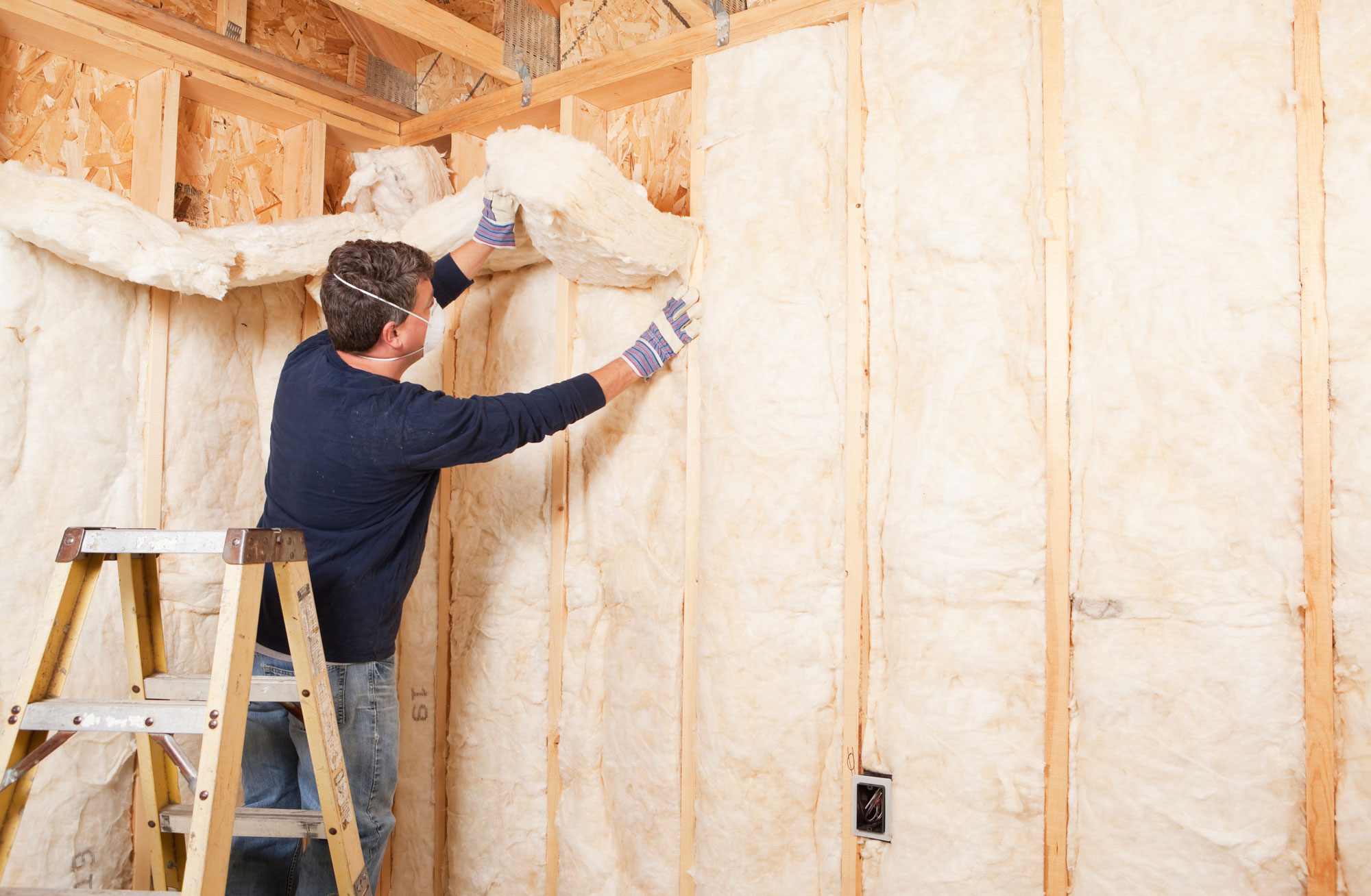 contractor installing wall insulation 